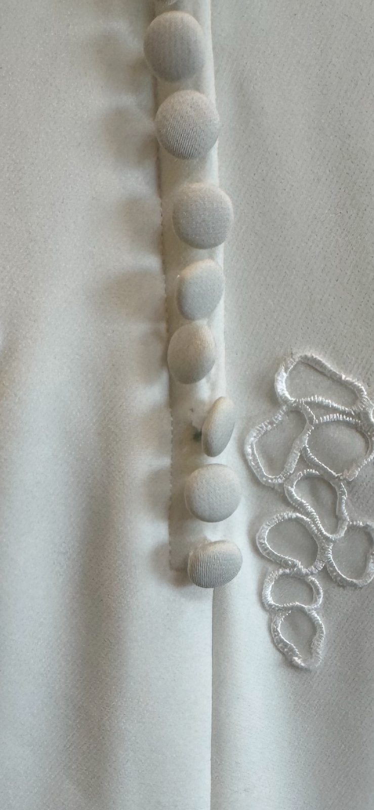 Row of covered buttons and hand-worked thread loops on a bridal closure